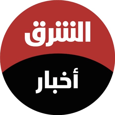 Circular logo divided horizontally with red and black halves containing white Arabic text